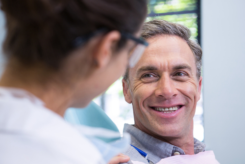 Closeup,Of,Happy,Patient,Looking,At,Dentist,In,Medical,Clinic