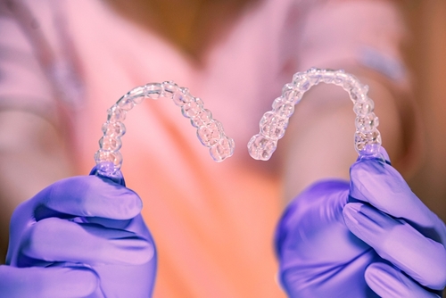 person holding invisalign trays