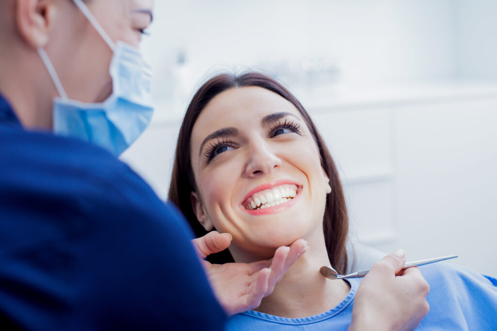 dentist cleaning female patients teeth in dental office