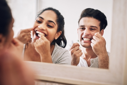 man and woman flossing